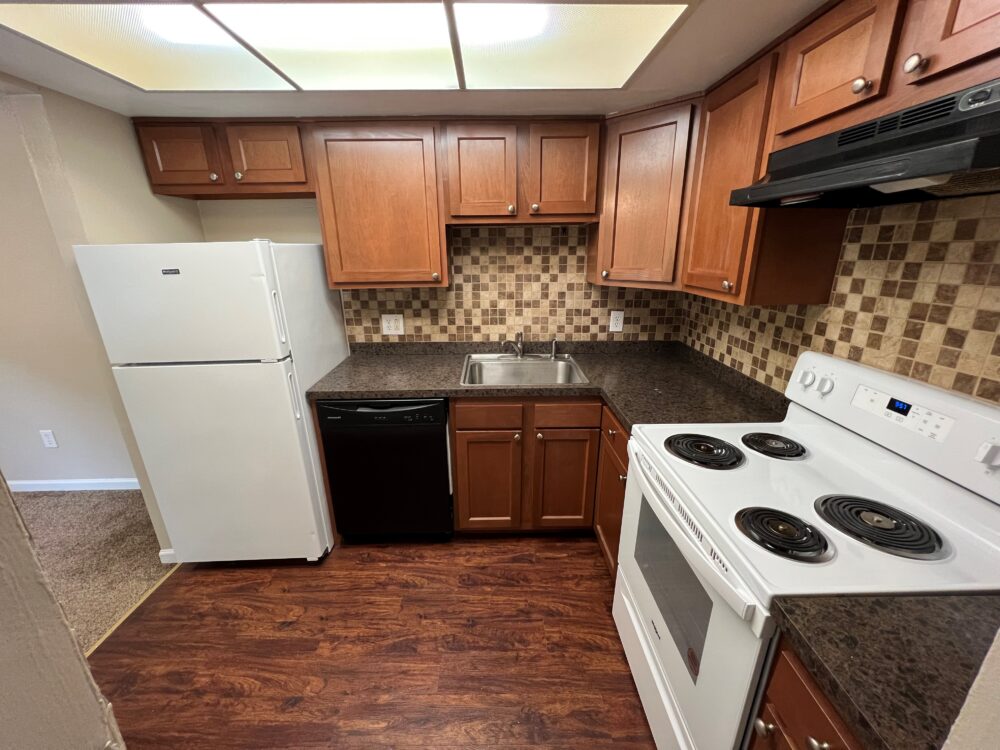 Kitchen with large appliances and wooden cabinets.