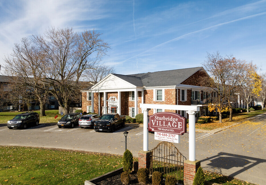 Sturbridge Village Apartments main building with alter sign in front.